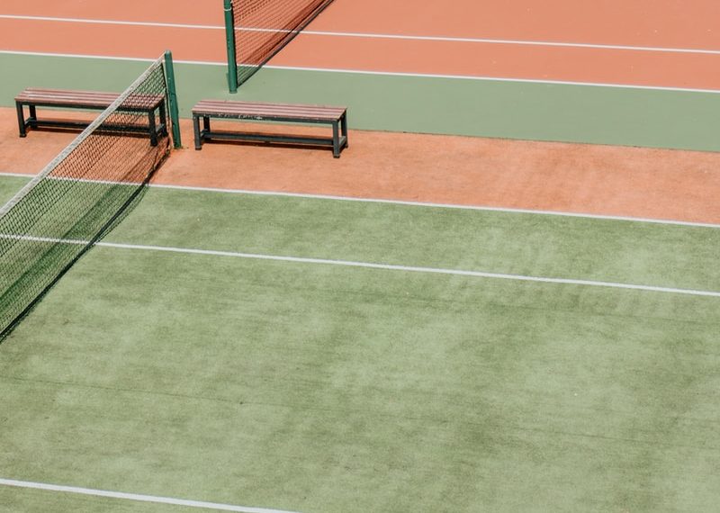 empty green and orange tennis fields